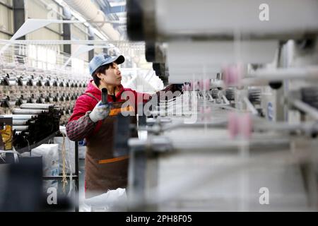 LIANYUNGANG, CHINA - 27. MÄRZ 2023 - Ein Arbeiter stellt Textilerzeugnisse an einer Produktionslinie in einem Privatunternehmen in Lianyungang Economic und Technol her Stockfoto