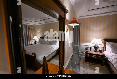 Berlin, Deutschland. 16. März 2023. Das Bett im Schlafzimmer der Royal Suite im Hotel Adlon ist übergroß und hat Blick auf das Brandenburger Tor. Einige Details eines königlichen Besuchs werden traditionell ruhig gehalten. Laut Insidern wird König Karl III. Dort wohnen, wo seine Mutter Königin Elizabeth II. Bereits Gast war. Eine der drei Präsidentensuiten im Hotel Adlon wurde zu ihren Ehren zur Royal Suite ernannt. Kredit: Jens Kalaene/dpa/Alamy Live News Stockfoto