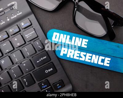 Kabellose Tastatur und Brille mit dem Wort ONLINE-PRÄSENZ. Geschäftskonzept. Stockfoto