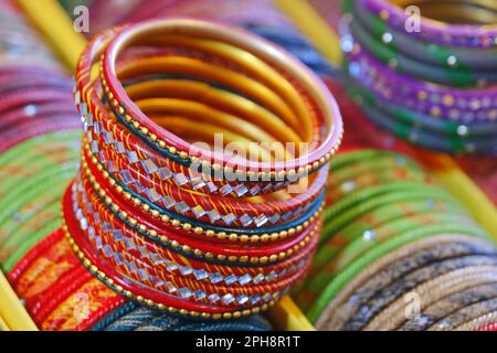 Bunte Bangles Display im Geschäft für Frauen, Metall-Bangles auf dem Regal für Verkauf angeordnet, Serie von Bangles. Selektiver Fokus. Stockfoto