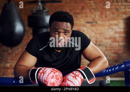 Starker afroamerikanischer Boxer in sportlicher Kleidung hat Übung im Fitnessstudio Stockfoto