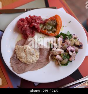 Eine köstliche Vorspeise aus Piedmont. Steak Tartare, Carpaccio, gefüllte Paprika und Salat Stockfoto