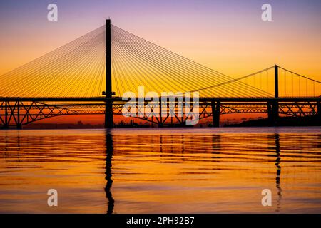 Sonnenaufgang über Queensferry Crossing, Forth Road Bridge und Forth Bridge auf Firth of Forth, South Queensferry, Edinburgh. Foto: Montag, 27. März 2023. Stockfoto