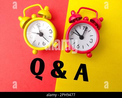 Farbiger Wecker mit den Worten Q UND A auf farbigem Hintergrund. Stockfoto