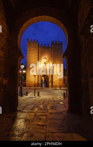 Toledo, Spanien. Blick zur blauen Stunde eines maurischen Bogens auf die Alcantara-Brücke und die Altstadt Stockfoto