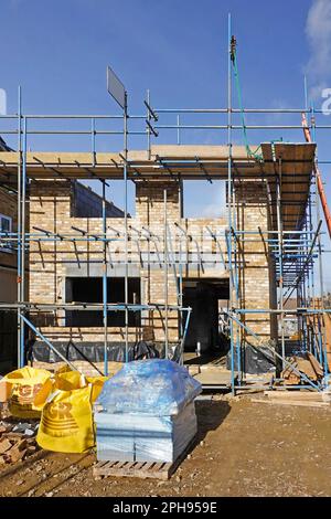 Vordertüren- und Fensteröffnungen in Richtung der Mauern in der Haupthöhe des neuen freistehenden Hauses bilden sich im Bau des Aufbaus England UK Stockfoto
