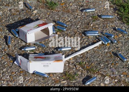 Kanister, Kapseln aus Stickoxid, Lachgas auf dem Boden verstreut, Bournemouth UK Stockfoto