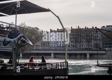 Frankreich, Lyon, 2023-03-22. Zwei junge Frauen trinken auf einem Barkahn auf der Rhône. Stockfoto