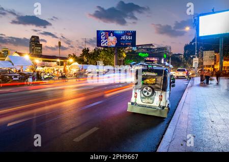 Phnom Penh, Kambodscha-Dezember 23. 2022: Als Licht von vorbeifahrenden Verkehrsstreifen vorbeizieht, erwacht der beliebte Markt in der Dämmerung zum Leben und zieht viele Khmer an Stockfoto