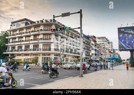 Phnom Penh, Kambodscha-Dezember 23. 2022: Viele Motorräder, Autos und Moto-Rikschas passieren Gebäude im französischen Kolonialstil, entlang der Uferpromenade von Tonle SAP Stockfoto