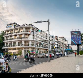 Phnom Penh, Kambodscha-Dezember 23. 2022: Viele Motorräder, Autos und Moto-Rikschas passieren Gebäude im französischen Kolonialstil, entlang der Uferpromenade von Tonle SAP Stockfoto