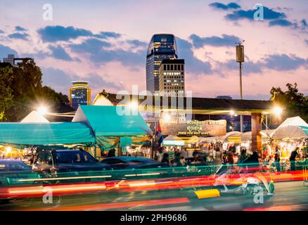 Phnom Penh, Kambodscha-Dezember 23. 2022: Mit bunten Lichtstreifen von vorbeifließendem Verkehr vor seinem Eingang kommt der Markt nachts, als Mensch Stockfoto