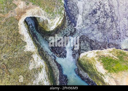 Atemberaubendes Naturkonzept. Über dem oder See aus der Vogelperspektive mit türkisfarbenem Wasser umgeben von Hügeln. Hochwertiges Foto Stockfoto