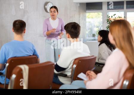 Junge Professorin, die das Thema einer Gruppe von Schülern erklärt Stockfoto