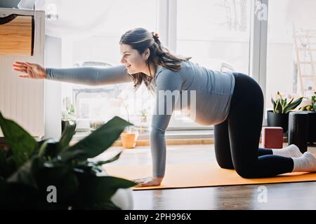 Vorteile des pränatalen Yogas für Schwangere, einschließlich Stresslinderung und verbesserte Flexibilität. Pränatales Yoga für das dritte Trimester zu Hause. Posiert für Stockfoto