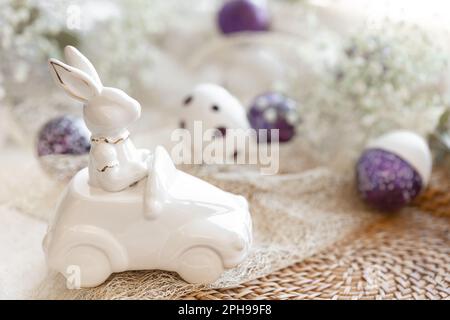 Festlicher Osterhintergrund mit dekorativem Keramikhasen. Stockfoto