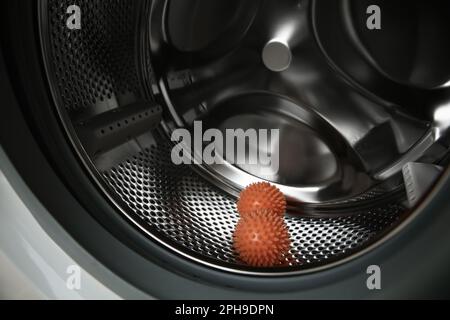 Trocknerkugeln in Waschmaschinentrommel, Nahaufnahme Stockfoto