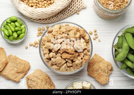 Verschiedene Bio-Soja-Produkte auf weißem Holztisch, flach liegend Stockfoto