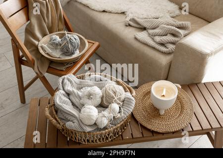 Fäden zum Stricken im Innenraum, eine gemütliche Komposition mit Garn. Stockfoto