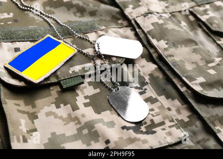 Ukrainische Armeeflagge und militärische ID-Tags auf Tarnuniform Stockfoto