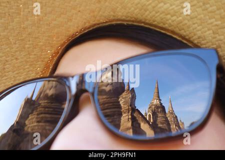 Eine Gruppe von berühmten Pagoden des Wat Phra Si Sanphet Tempels in Ayutthaya, Thailand, die sich mit der Sonnenbrille für weibliche Besucher beschäftigen Stockfoto