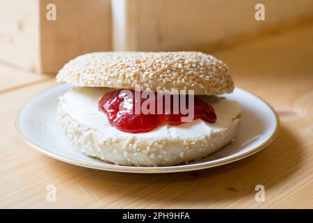 Köstliche süße Marmelade und Käsesandwich auf Bagelbrot. Ein Bagel ist ein Brot, das traditionell aus Weizenmehl hergestellt wird und normalerweise ein Loch in der Mitte hat. Stockfoto