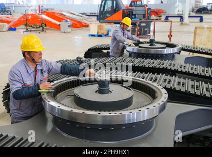 LIANYUNGANG, CHINA - 27. MÄRZ 2023 - Ein Arbeiter montiert Teile eines Hydraulikbaggers in einer Produktionswerkstatt von Luyou Heavy Industry Co LTD in Lianyungang, Stockfoto