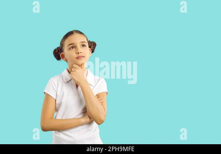 Junge Mädchen, die sich einen Plan auf hellblauem Hintergrund vorstellen, nachdenken, Entscheidungen treffen oder einen Plan ausarbeiten. Stockfoto