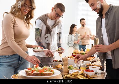 Eine Gruppe von Personen, die ein Brunch-Buffet zusammen im Haus genießen Stockfoto