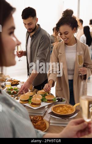 Eine Gruppe von Personen, die ein Brunch-Buffet zusammen im Haus genießen Stockfoto