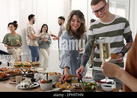 Eine Gruppe von Personen, die ein Brunch-Buffet zusammen im Haus genießen Stockfoto