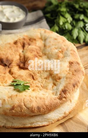 Laibe mit köstlichem hausgemachtem Pita-Brot auf Holztisch, Nahaufnahme Stockfoto