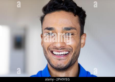 Nahaufnahme eines glücklichen, birassischen Mannes, der lächelt und wegschaut Stockfoto
