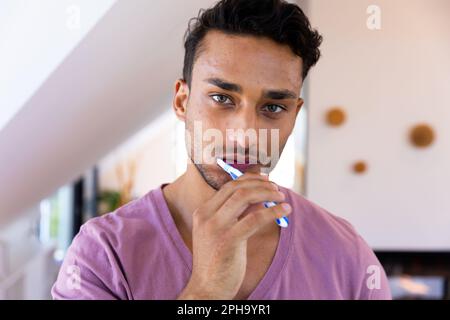 Porträt eines birassischen Zahnputzers im Badezimmer Stockfoto