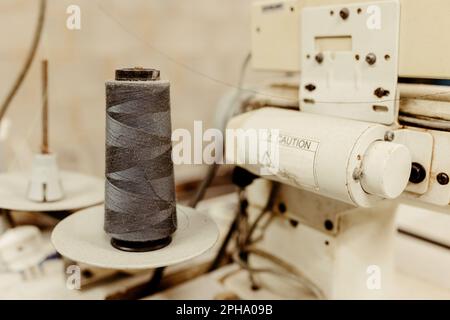 Nahaufnahme einer Nähmaschine mit bearbeiteter Fadenspule Stockfoto