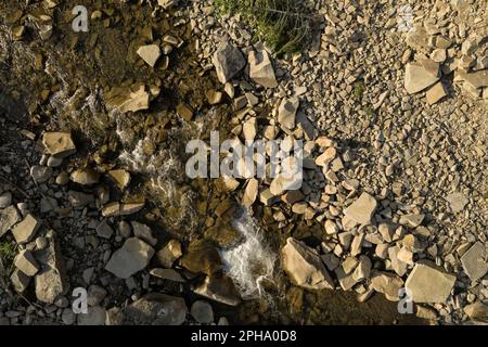Blick aus der Vogelperspektive auf felsiges Gelände mit Bach. Drohnenfotografie Stockfoto