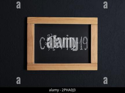 Tafel mit Wort Covid19 auf schwarzem Hintergrund, Draufsicht Stockfoto