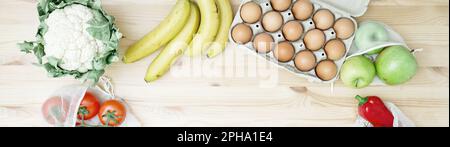 Verschiedene Speisen auf einem Holztisch. Gemüse, Obst, Eier. Webbanner, Kopierbereich Stockfoto