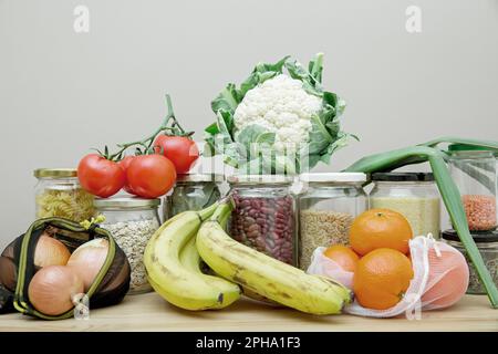 Zusammensetzung von Lebensmitteln in wiederverwendbaren Verpackungen, Netzbeuteln und Glasbechern. Das Konzept von Leben und Einkaufen ohne Verschwendung. Kein Plastik. Stockfoto