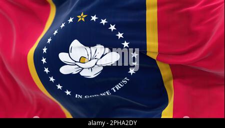 Mississippi Staatsflagge flattert. Blaues Mittelfeld mit roten Seitenbändern, goldenen Streifen. Magnolienblüte in der Mitte, umgeben von 20 weißen Sternen, La Stockfoto