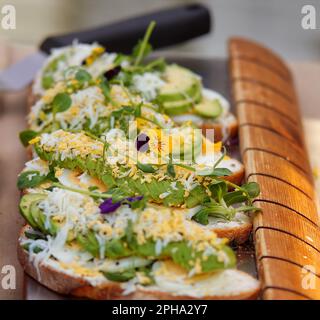 Ein Stand mit Osterdelikatessen auf dem Bauernmarkt in Prag, Brot mit Eieraufstrich, Avocado und grünen Kräutern. Stockfoto