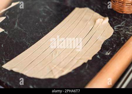 Blätterteig auf einem Tisch in Streifen geschnitten Stockfoto