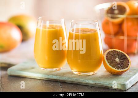 Zwei Mango-Cola oder Kesar-Milch in Gläsern. Indisches gesundes ayurvedisches kaltes Getränk mit Mango. Frischeküche aus Joghurt, Wasser, Gewürzen, Obst und Ik. A. Stockfoto