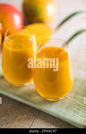 Zwei Mango-Cola oder Kesar-Milch in Gläsern. Indisches gesundes ayurvedisches kaltes Getränk mit Mango. Frischeküche aus Joghurt, Wasser, Gewürzen, Obst und Ik. A. Stockfoto