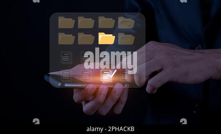 Geschäftsmann, der den Dokumentenordner auf einem mobilen Bildschirm berührt. Eine Erweiterung der Digitalisierung und Prozessautomatisierung zur effizienten Verwaltung von Dateien, Wissen und Stockfoto