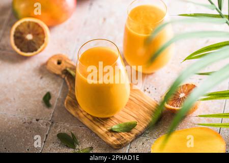 Zwei Mango-Cola oder Kesar-Milch in Gläsern. Indisches gesundes ayurvedisches kaltes Getränk mit Mango. Frischeküche aus Joghurt, Wasser, Gewürzen, Obst und Ik. A. Stockfoto