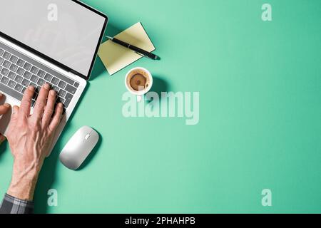 Hände eines Mannes über Laptop mit leerem Bildschirm. Draufsicht mit leerem Kopierbereich. Stockfoto