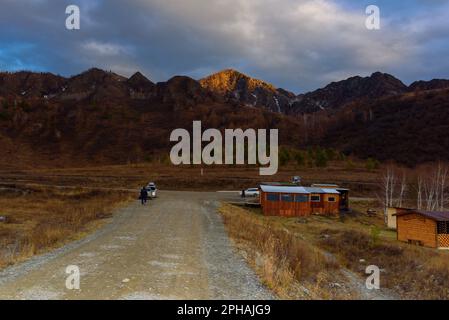 Altai, Russland - 02. Oktober 2022 Urlauber fahren abends in die Berge zu den Autos in Altai. Stockfoto