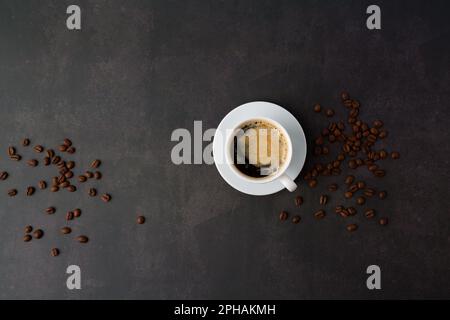 Kaffeetasse mit gerösteten Bohnen auf Stein Hintergrund. Ansicht von oben mit Platz für Ihren Text kopieren Stockfoto