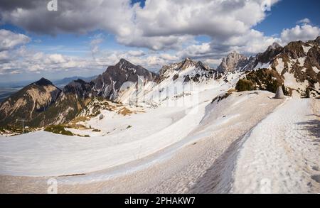 Eine malerische Landschaft mit schneebedeckten Berggipfeln und sanften Wolken am Himmel, mit einem gewundenen Pfad, der das Auge durch das Bild von Österreich führt Stockfoto